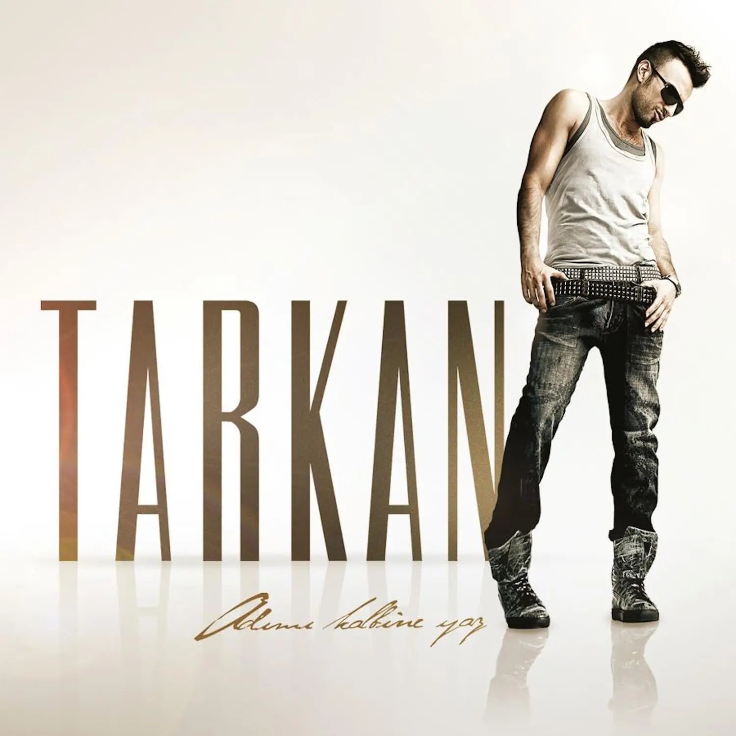 Tarkan standing with sunglasses on white background with Adımı Kalbine Yaz album title and large TARKAN text